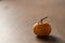 Small organic tangerine with stem on wood table