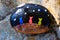 Small painted rock with picture of three colorful cats on a fence