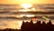 Small paper beach umbrellas stand in the sand at sunrise on the sandy beach