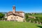 Small parish church on green lawn in Italy.