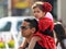 A small participant of the carnival of Adloyada sits on her father`s shoulders in Nahariyya, Israel