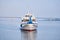 Small passenger motorship on the river and road bridge in the morning haze in the background