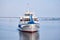 Small passenger motorship on the river and road bridge in the morning haze in the background