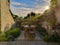 Small patio garden with vintage cement tiles and numerous plants in summertime during sunrise