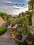 Small patio garden with vintage cement times and full with numerous plants during sunrise in summertime