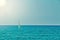 Small personal sailboat sailing in the open flat sea on a summer day