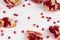 Small pieces of pomegranate scattered randomly on a white background
