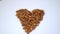 Small pile of almonds in a heart shape on a white table