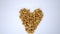 Small pile of peanuts in a heart shape on a white table