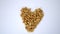 Small pile of peanuts in a heart shape on a white table
