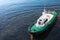 Small pilot boat with green deck on sea water