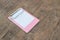 Small pink clipboards with a blank sheet of paper on wooden background