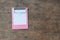 Small pink clipboards with a blank sheet of paper on wooden background.