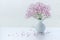 Small pink gypsophila flowers on white table.