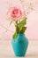 Small pink rose on blue vase