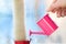 Small pink watering can in a female hand watering a cactus on an