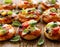 Small pizzas with the addition of cherry tomatoes, olives, mozzarella cheese and fresh basil on a rustic wooden background