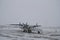 A small plane on a tarmac being readied for takeoff in a remote communityin the late morning with snow on the ground