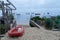Small plastic dingy fishing boat moored on sand beach seascape aside wooden pontoon and access sea beach