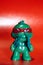 A small, plastic toy depicting a ninja, a vertical photo on a red background.