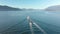 A small pleasure craft towing a dingy with Howe Sound and the mountains in the background on a sunny day. 24FPS 4K.