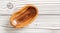 Small polished rosewood bowl on white boards desk, closeup view from above