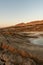 Small pond in a deserted area surrounded by hills under the sunlight and a blue sky