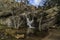 The small pond of the waterfall. Rocks, trees and water