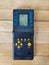 Small portable console, tetris on the wooden background