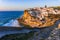 Small Portugal village Azenhas do Mar on cliff on coastline with sunset