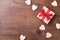 Small present or gift box decorated bow ribbon and wooden hearts on rustic table top view. Valentines or Mother day greeting card.
