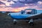 Small private airplane parked at the airfield at scenic sundown