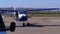 Small private airplane with a rotating propeller standing on the aircraft parking on a small airfield