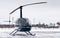 Small private blue helicopter on snowy heliport.