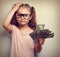 Small professor in eye glasses scratching head, holding money an