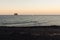 The small promontory of Strombolicchio from Stromboli`s black beach at sunset in Sicily, Italy