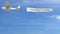 Small propeller airplane towing banner with ADVERTISING caption in the sky