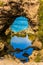 Small puddle of quiet water in an arch. Coastal rocks formed a picturesque arch of sandstone. Great Ocean Road of Australia. The