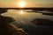 A small puddles in the sand after low tide in sunset light