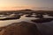 A small puddles in the sand after low tide in sunset light