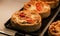 Small puff pies with vegetables and meat, quiches in a cafe window.