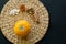 Small pumpkin with seeds, little glass can of honey, walnuts and cinnamon sticks on a circle mat/napkin made of water hyacinth on