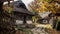 Small, quaint cottage with thatched roof and an old-fashioned look. It is located on dirt road or pathway in