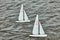 small radio-controlled sailing boats sailing on water, boat numbers on sails