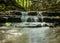 A small rapid river flows through dolomite rocks, long-term exposure, gentle and fuzzy river water, colorful autumn leaves and dry