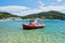 Small red fishing boat at Panormos bay in front of Panormos beach, island of Skopelos