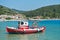 Small red fishing boat at Panormos bay in front of Panormos beach, island of Skopelos
