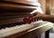 The small red heart was put on piano keys by human hand,warm light tone