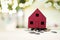 Small red house standing on a heap of coins.