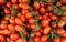 Small red italian tomatoes called Datterini, with branches and little leaves. Top view, food background